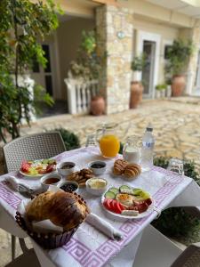 a table with breakfast foods and orange juice on it at Anel Studios in Vlorë