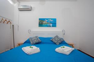 a bedroom with a blue bed with towels on it at Casa BabbaLuciana in Mondello