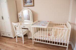 a nursery with a crib and a dressing table and a mirror at Dom całoroczny nad Bugiem in Wasilew Szlachecki