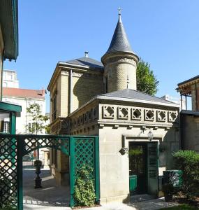 an old building with a gate and a tower at Pavillon indépendant en plein centre de Vichy in Vichy