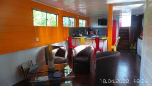 salon z pomarańczowymi ścianami oraz stołem i krzesłami w obiekcie LES AMIS D'ULYSSE w mieście Chagny