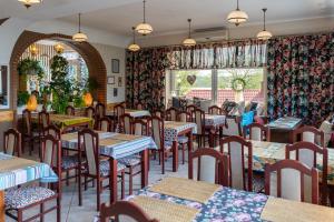 a restaurant with tables and chairs and a window at Gościniec Skolimówka Restauracja i pokoje ze śniadaniem na Kaszubach in Chmielno