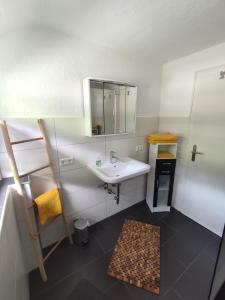 ein Bad mit einem Waschbecken und einem Spiegel in der Unterkunft Ferienwohnung Schwarzwaldliebe in Bad Peterstal-Griesbach