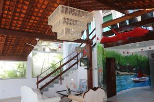 a living room with a staircase and a painting on the wall at Pousada Maramazon in São Luís