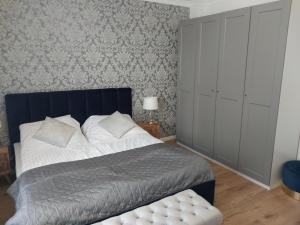 a bedroom with a bed with a blue headboard at APARTAMENT PIASTOWSKI in Polanica-Zdrój