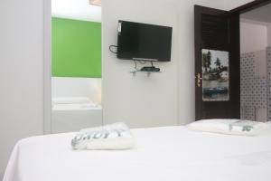 a bedroom with a white bed with a tv on the wall at Pousada Maramazon in São Luís +92 photos