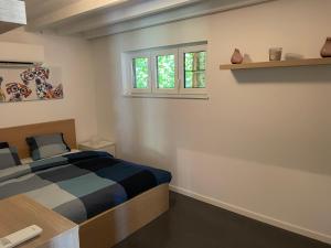 a bedroom with a bed and two windows at Guest House en famille ou en couple à la campagne in Romsée