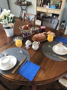 een houten tafel met eten en drinken erop bij Augustodun'Home in Autun