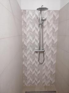 eine Dusche im Bad mit Fliesenboden in der Unterkunft Werner Apartman in Mohács
