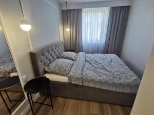 sypialnia z łóżkiem, krzesłem i lustrem w obiekcie SEASIDE APART w Kołobrzegu