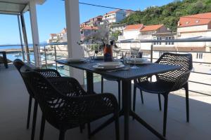 un tavolo e sedie su un balcone con vista sull'oceano di Captains beach home a Čara