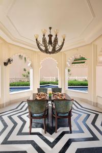 烏代浦的住宿－Aurika, Udaipur - Luxury by Lemon Tree Hotels，一间带桌椅和吊灯的用餐室