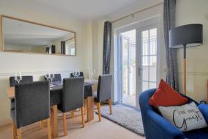 comedor con mesa y sofá azul en Anning's View, en Lyme Regis