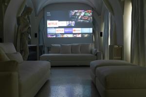 a living room with two couches and a large screen at Sant'Agnese DOMUS in Milan