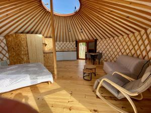 um quarto com uma cama e um sofá numa tenda em Yourte 2-4 personnes avec SPA em Saint-Laurent-de-Lévézou