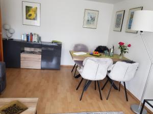 a dining room with a table and two white chairs at Ferienwohnung Brohltal-Aue in Burgbrohl