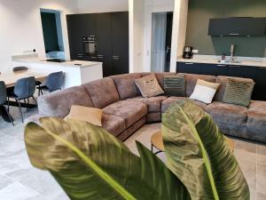 a living room with a couch and a large plant at Swanky villa in Zeewolde with garden in Zeewolde