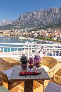 einen Tisch mit zwei Gläsern Wein auf dem Balkon in der Unterkunft Apartel Park Osejava in Makarska