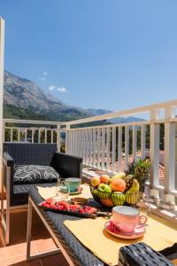 a table with a bowl of fruit on a balcony at Apartel Park Osejava in Makarska