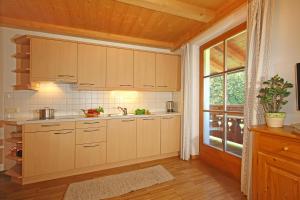 een keuken met witte kasten en een groot raam bij Niglutsch Apartement Kastelruth in Castelrotto