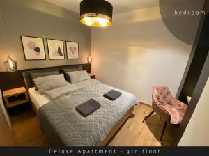 um quarto com uma cama e uma cadeira rosa em Piran Rooftop Apartments em Piran