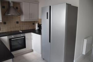 a kitchen with a refrigerator and a stove at 2 bed Apartment Ballycastle Seconds to Seafront in Ballycastle