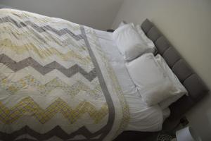 a bed with a quilt and pillows on it at 2 bed Apartment Ballycastle Seconds to Seafront in Ballycastle