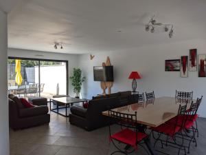un soggiorno con divano, tavolo e sedie di LA LOGIA Gîtes pour 20 personnes a Rilly-la-Montagne