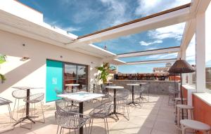 un patio avec des tables et des chaises ainsi qu'un bar dans l'établissement Apartamentos Málaga Premium - Calle Granada, à Malaga