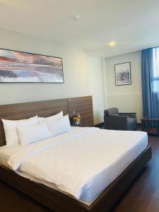 - une chambre avec un grand lit blanc dans l'établissement Central Park Saigon Hotel, à Hô-Chi-Minh-Ville