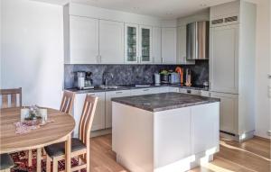 cocina con armarios blancos y mesa de madera en Gorgeous Apartment In Kristiansand With Kitchen, en Kristiansand