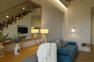 a living room with a blue couch and a mirror at FOUR REASONS in Paralia Katerinis