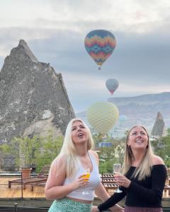 two women with glasses of wine and hot air balloons at Local Cave House Hotel in Goreme