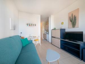 a living room with a blue couch and a tv at Mimose Little House in Misano Adriatico +6 photos