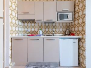a kitchen with white cabinets and a microwave at Mimose Little House in Misano Adriatico