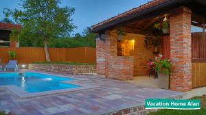 a swimming pool in a backyard with a brick house at Vacation home Alan 2 in Kulen Vakuf