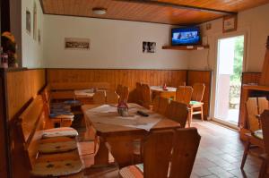 a restaurant with wooden tables and chairs and a television at Chata Nová Huť in Nové Hutě