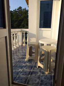 a balcony with two tables and two stools at Vacation Home Yoanna in Tryavna
