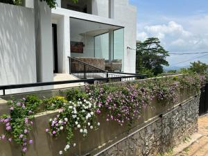 een steunmuur met bloemen op een huis bij Hotel Kandyan View ''Free pickup from Kandy city'' in Kandy