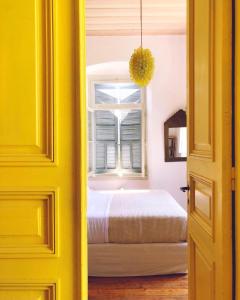Villa Clara Leros في اجيا مارينا: باب اصفر يؤدي الى غرفة نوم بسرير