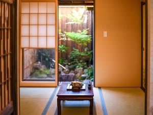 a room with a table in front of a door at 慶有魚·東山(Kyotofish·Higashiyama)*景区核心町屋*地暖赏庭浴缸*京都民宿认证 in Kyoto
