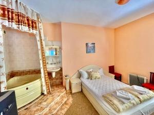 a bedroom with a bed and a tub and a sink at Jackie House Varna in Varna City