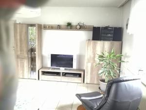 sala de estar con TV y silla en Ferienwohnung Vulkaneifel, en Mehren