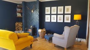 a living room with a yellow couch and a chair at Ronachan in Clachan