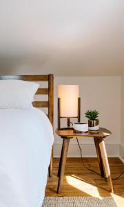 a bedroom with a bed and a table with a lamp at The Flats East in Wellington