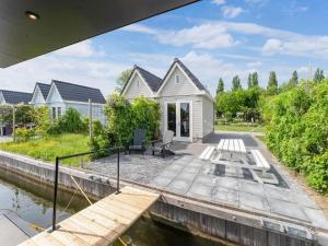 una casa blanca con un muelle junto a un cuerpo de agua en Brand new Boathouse on the water in Stavoren with a garden en Stavoren