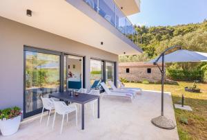 a patio with a table and chairs and an umbrella at Casa Bella in Lopud