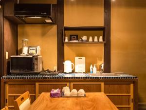 - une cuisine avec une table et un four micro-ondes dans l'établissement 慶有魚·老松(Kyotofish·Oimatsu)*百年松树町屋*京都繁华地带*近皇宫鸭川*民宿认证, à Kyoto