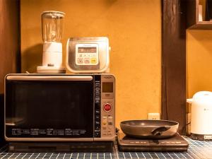 - un four micro-ondes et un bol au-dessus d'un comptoir dans l'établissement 慶有魚·老松(Kyotofish·Oimatsu)*百年松树町屋*京都繁华地带*近皇宫鸭川*民宿认证, à Kyoto