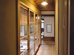 une porte ouverte sur une pièce avec du parquet dans l'établissement 慶有魚·老松(Kyotofish·Oimatsu)*百年松树町屋*京都繁华地带*近皇宫鸭川*民宿认证, à Kyoto